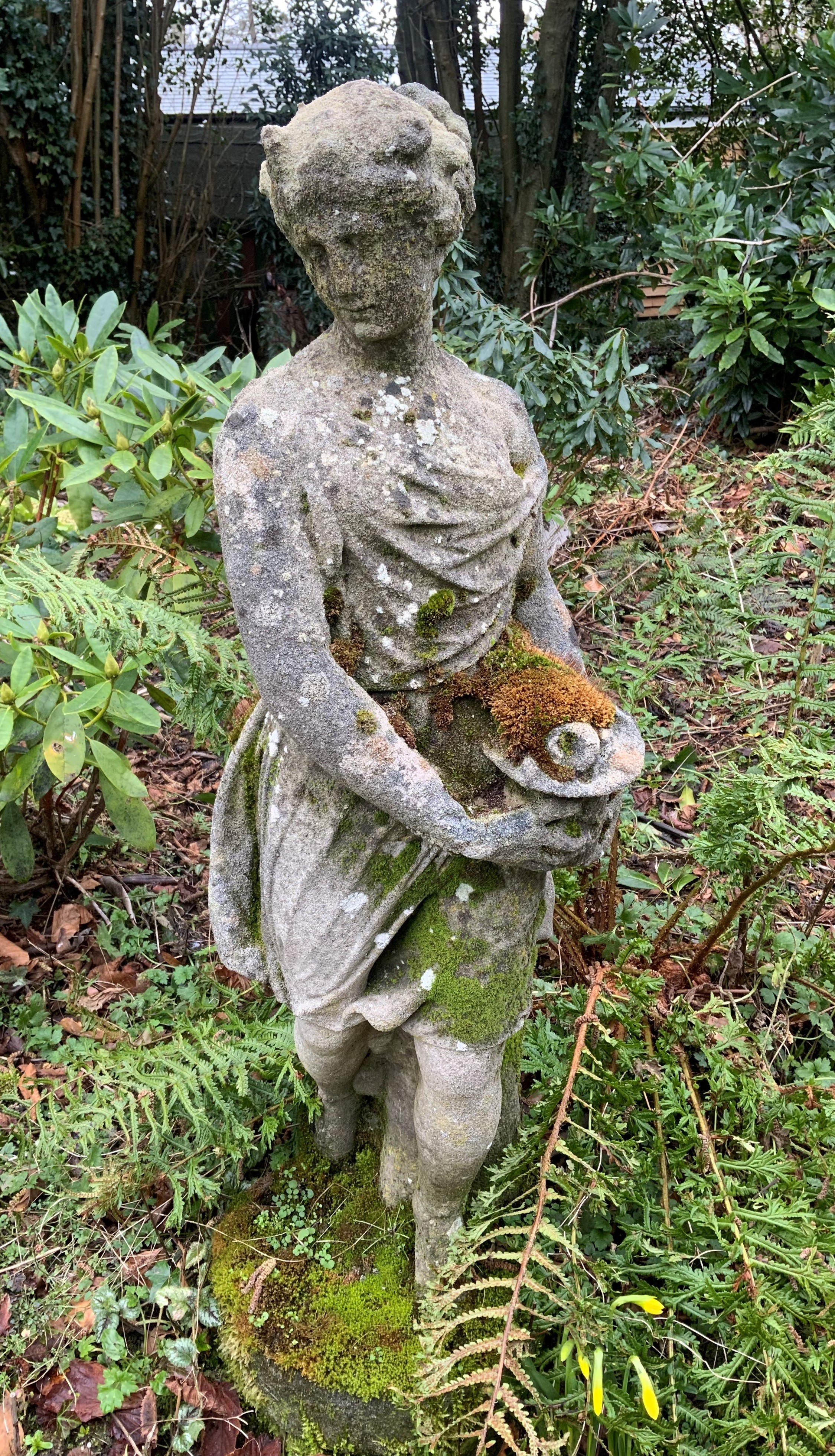 A reconstituted stone figure of a girl holding a basket of flowers, height 97cm